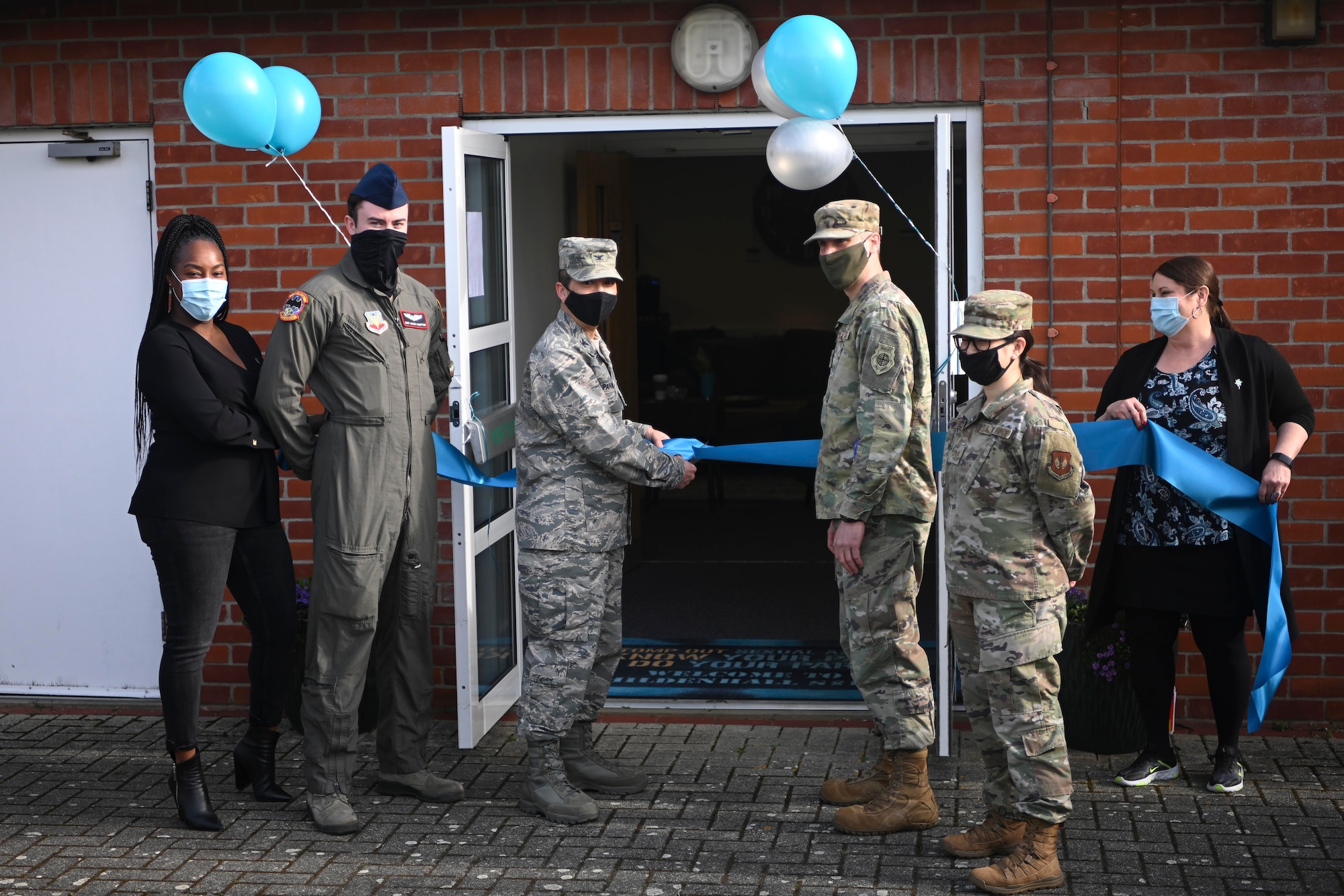 U.S. Air Force Col. Troy Pananon, 100th Air Refueling Wing commander, cuts a ribbon to celebrate the proclamation of April as Sexual Assault Awareness and Prevention Month at Royal Air Force Mildenhall, England, March 31, 2021. Airmen are empowered to intervene when they encounter conduct that could lead to sexual assault. (U.S. Air Force photo by Senior Airman Joseph Barron)