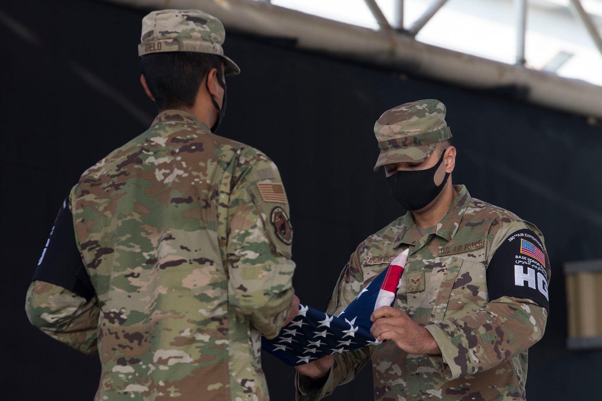 Senior Airman May Zamora Castillo folds a U.S. flag during a ceremony.