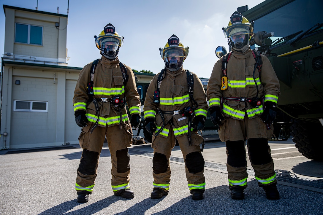 (From left) U.S. Marine Corps Lance Cpl. Thomas Diffley, Pfc. Elijah Stewart and Lance Cpl. Nicklas Martin, expeditionary firefighting and rescue specialists with Headquarters and Headquarters Squadron, Marine Corps Installations Pacific, pose for an environmental photo on Marine Corps Air Station Futenma, Okinawa, Japan, April 7, 2021. EFR specialist Marines with H&HS provide aircraft rescue and firefighting services in support of airfield operations and respond to any fire-related emergencies and situations with a maximum response time of five minutes. Stewart is a native of Independence, Missouri, Diffley is a native of Dallas, Texas and Corkern is a native of Seattle, Washington.
