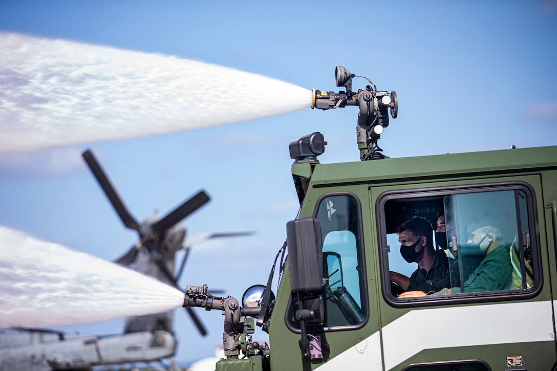 U.S. Marines with Headquarters and Headquarters Squadron, Marine Corps Installations Pacific, conduct a turret drill with an Oshkosh P-19R Aircraft Rescue and Firefighting Vehicle on Marine Corps Air Station Futenma, Okinawa, Japan, April 7, 2021. EFR specialist Marines with H&HS provide aircraft rescue and firefighting services in support of airfield operations and respond to any fire-related emergencies and situations with a maximum response time of five minutes.