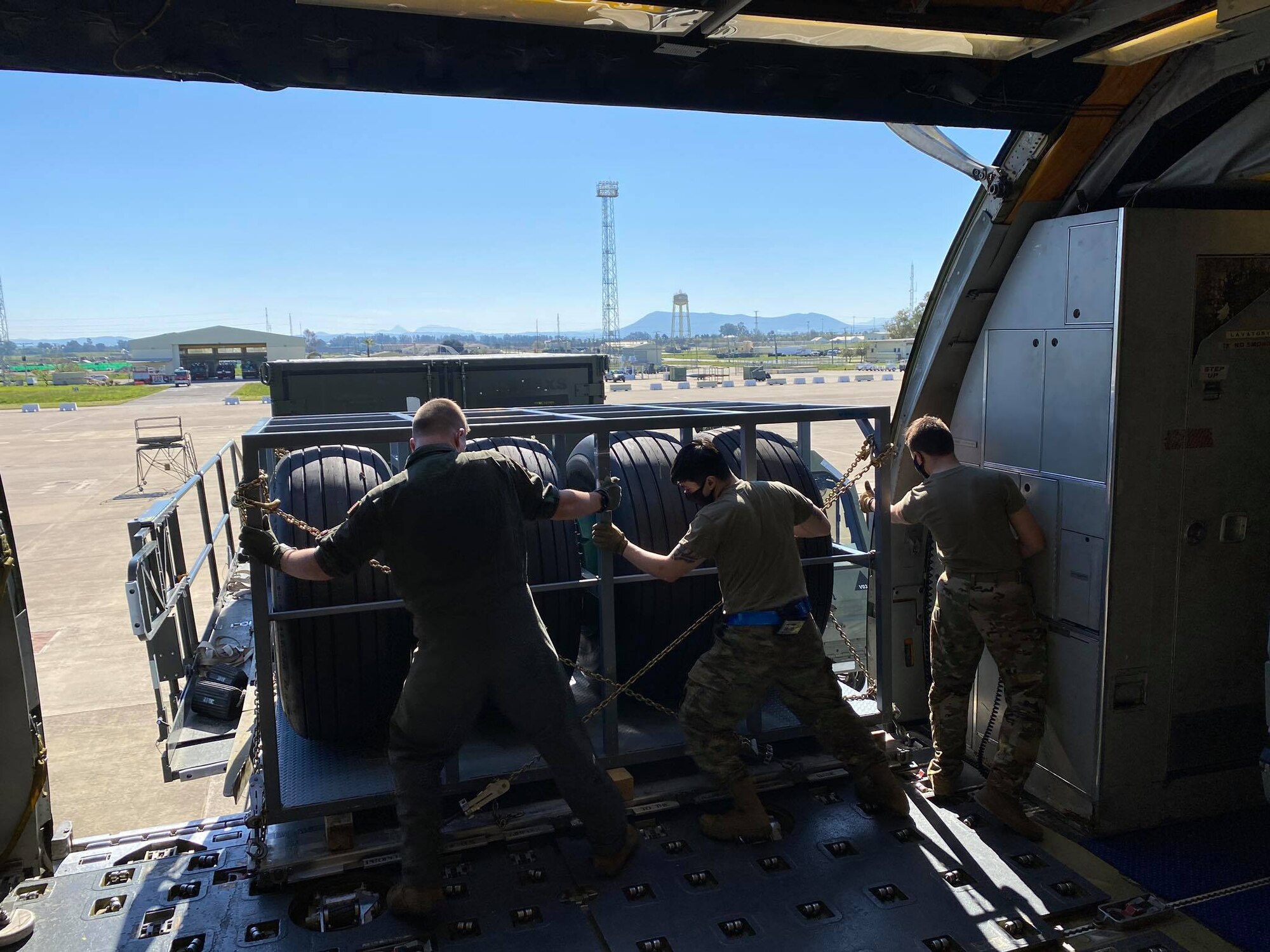 Air Transportation Specialists from the 721st Aerial Port Squadron and 726th Air Mobility Squadron work with maintainers from the 725th Air Mobility Squadron to download cargo from a KC-135 at Morón Air Base, April 6, 2021. The cargo is part of the CORONET EAST Operations, which supports U.S. Central Command area of responsibility with aerial refueling capabilities for warfighting assets. (U.S. Air Force photo by Staff Sgt. Michael Dodd)