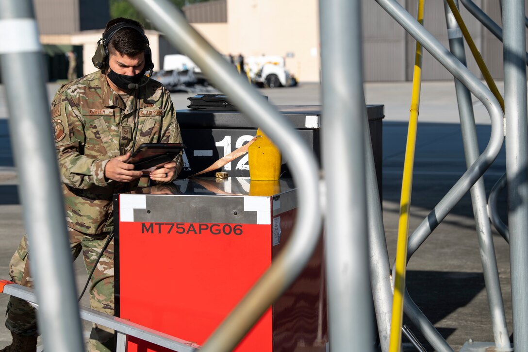 A photo of an Airman checking an electronic device.