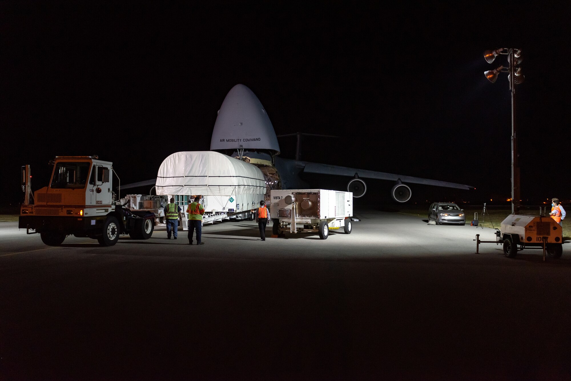 Airmen and Guardians with the 45th Space Wing receives a Space Based Infrared System satellite from an Air Force C5-M Super Galaxy from Travis Air Force Base, Calif., which delivered the latest model of the series to Cape Canaveral Space Force Station, March 18, 2021. A crowd of government and industry partners, who will complete the satellite’s final assembly prior to its launch later this year, gathered on the Cape’s 'Skid Strip' to watch the off-loading of the satellite. (U.S. Air Force photo/Joshua Conti)