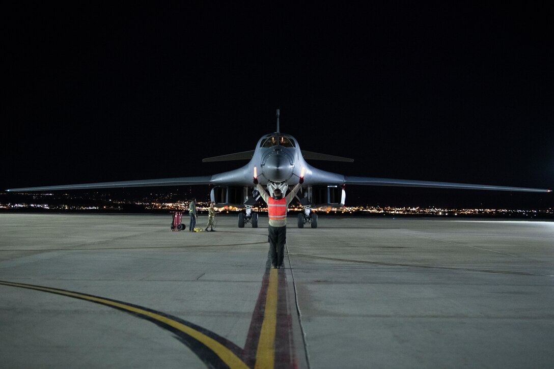 A crew chief assigned to the 37th Aircraft Maintenance Squadron marshals a B-1B Lancer onto the apron upon return from a Bomber Task Force Mission at Ellsworth Air Force Base, S.D., April 7, 2021.