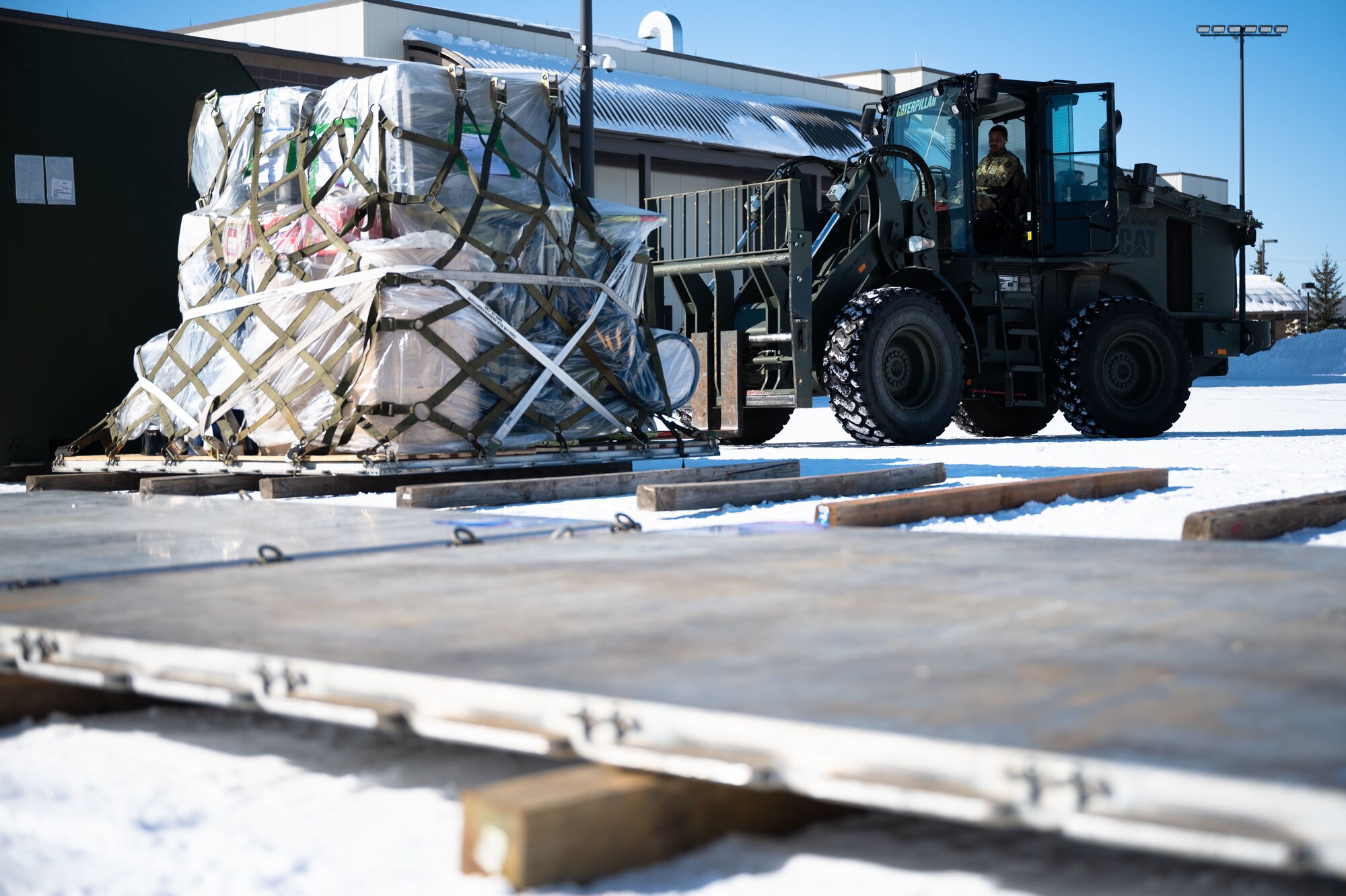 U.S. Air Force Airman 1st Class Cambrin Dixon, a 354th Logistics Readiness Squadron vehicle operator, picks up a cargo using a forklift during Arctic Gold 21-2 on Eielson Air Force Base, Alaska, April 6, 2021. AG 21-2 is a readiness exercise demonstrating the 354th Fighter Wing’s ability to generate F-35A Lightning II aircraft and deploy forces and cargo from across the wing. (U.S. Air Force photo by Airman 1st Class Jose Miguel T. Tamondong)