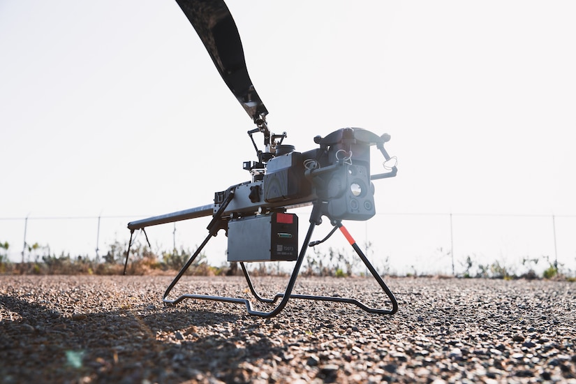 A small drone sits on the ground.