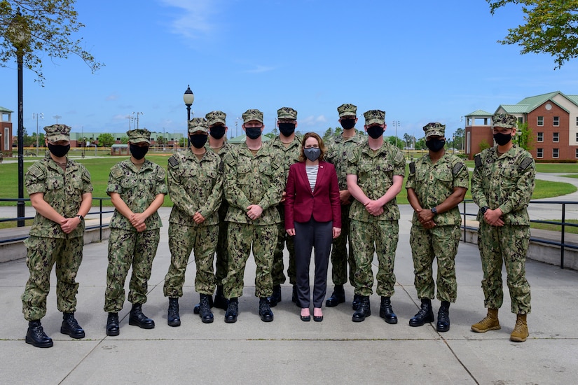 Deputy Secretary of Defense Kathleen H. Hicks stands with a group of service members.