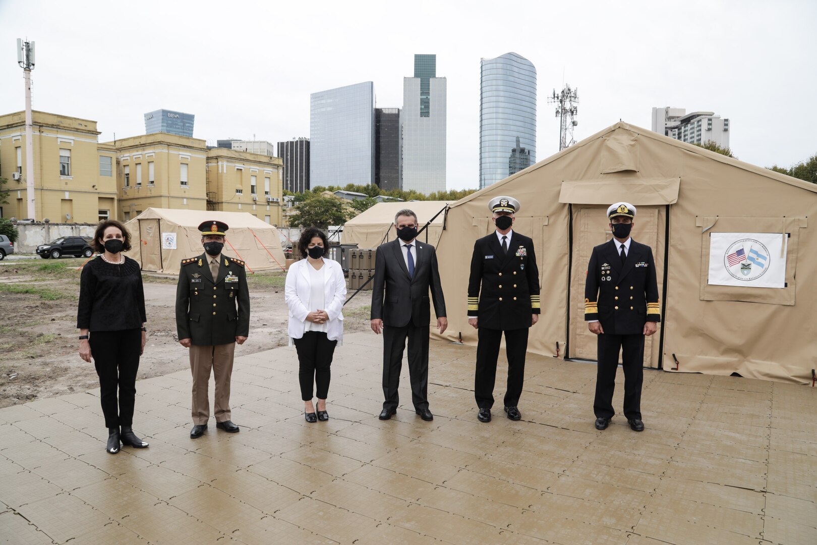 U.S. Southern Command’s commander, Navy Adm. Craig Faller, and Argentine Minister of Defense Agustin Rossi, pose for a photo with other senior leaders in front of three mobile hospitals donated by the United States to Argentina to support the nation’s COVID-19 response.