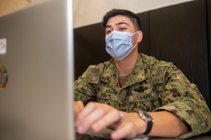 Hospital Corpsman 3rd Class Dillon Davis enters Sailors information into their medical records to track doses at the Naval Air Station Oceana vaccine site.