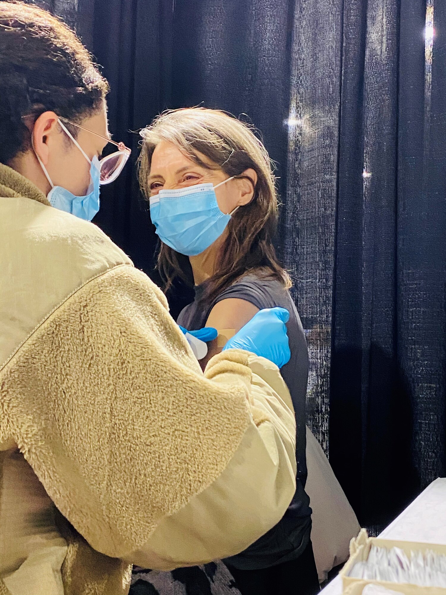 U.S. Air Force Senior Airman Arianna Gordon, 14th Health Care Operations Squadron Aerospace Medical technician, applies a band aid to the incision site to a patient, who just received the COVID-19 Pfizer vaccine, while deployed under FEMA, at Medgar Evers College, Brooklyn, New York Gordon has administered over 3,500 vaccines since arriving on Feb. 23, 2021, making her one of the sites top 3 vaccinators. (Courtesy photo)