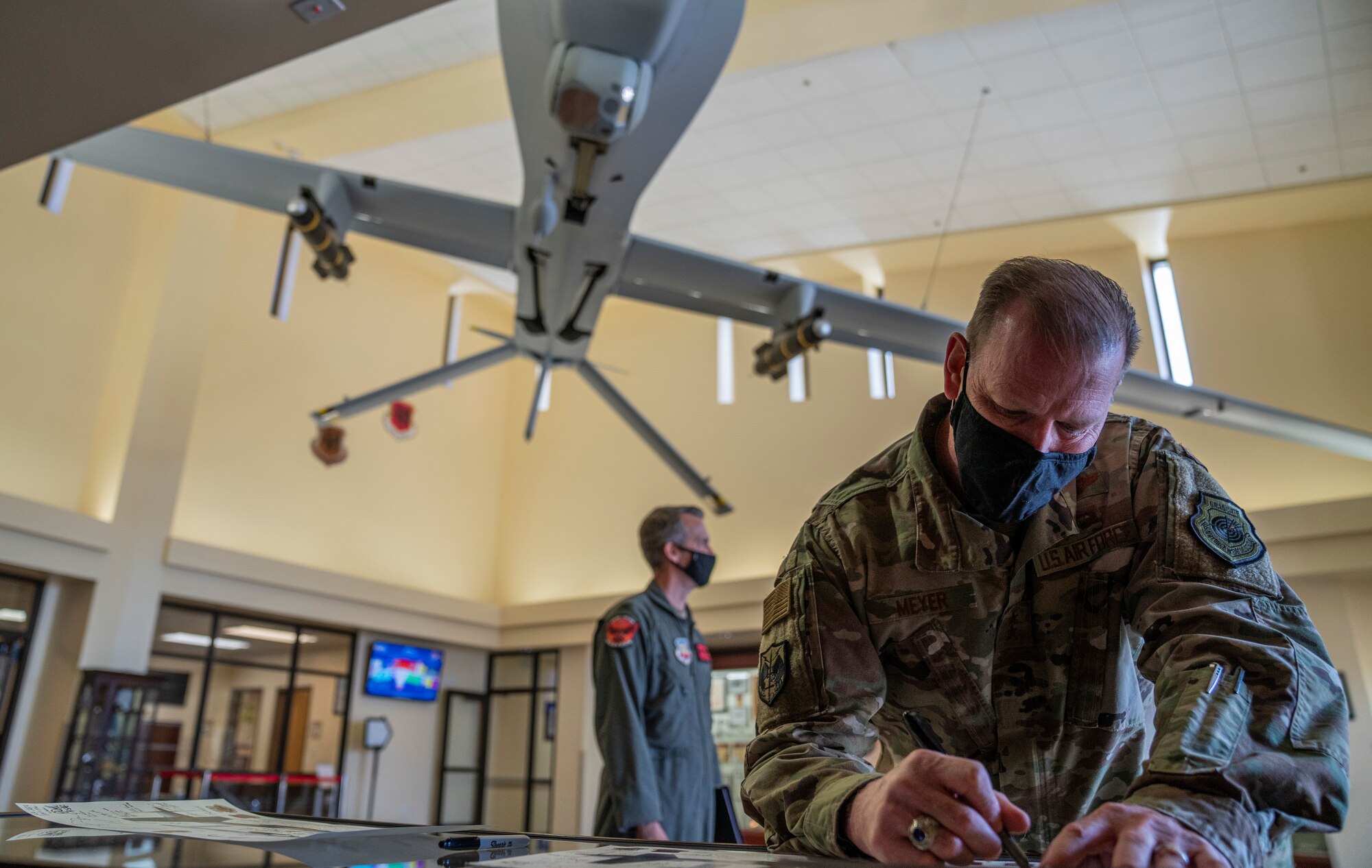 Maj. Gen. David Meyer signs a lithograph at Creech Air Force base inside the wing headquarters building.
