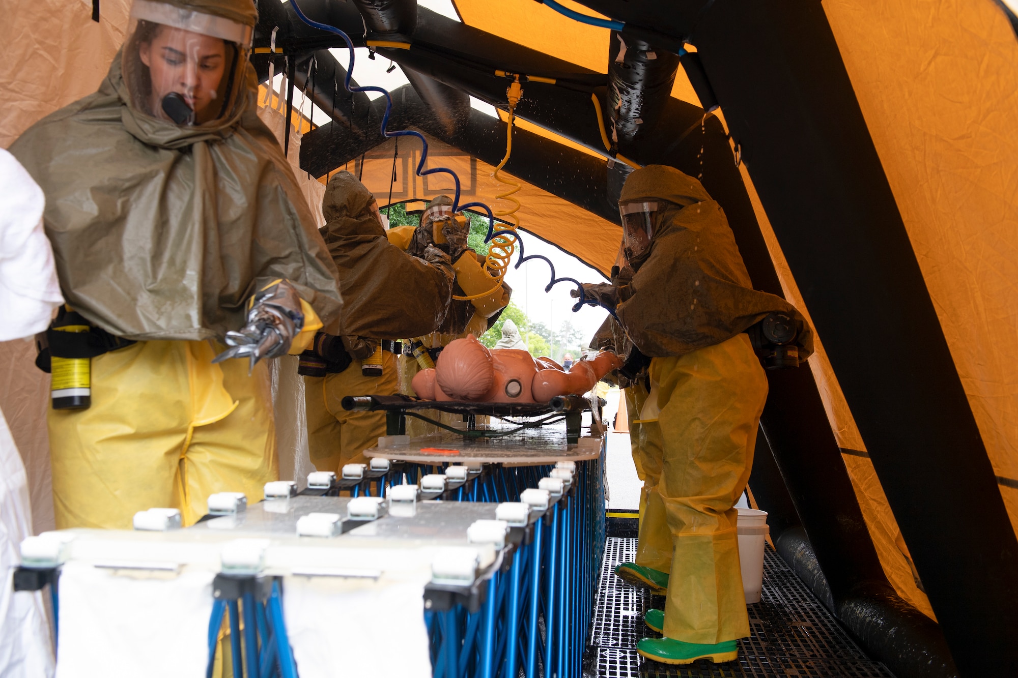 A photo of Airmen in a tent with a mock body.