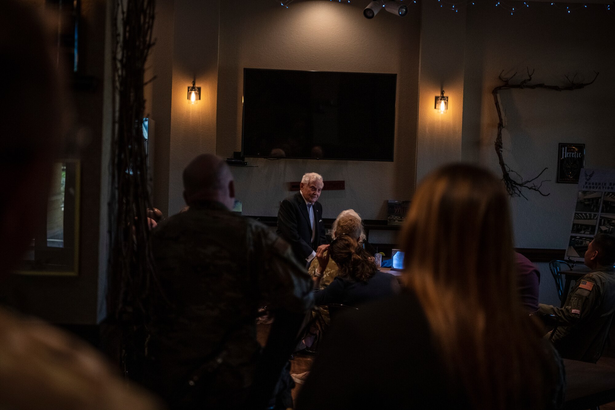 An older gentleman is making a speech and waving his arms.