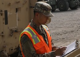 Army Reserve Spc. Feiyu He, a yard specialist deployed to Camp Arifjan, Kuwait, with the Lancaster, Pennsylvania-based 1185th Deployment and Distribution Support Battalion, reviews paperwork March 26, 2021 for rolling stock at Kuwait's Shuaiba Port. Chinese-born He is applying for U.S. citizenship with the support of the 1st Theater Sustainment Command's operational command post at the camp. (U.S. Army photo by Staff Sgt. Neil W. McCabe)