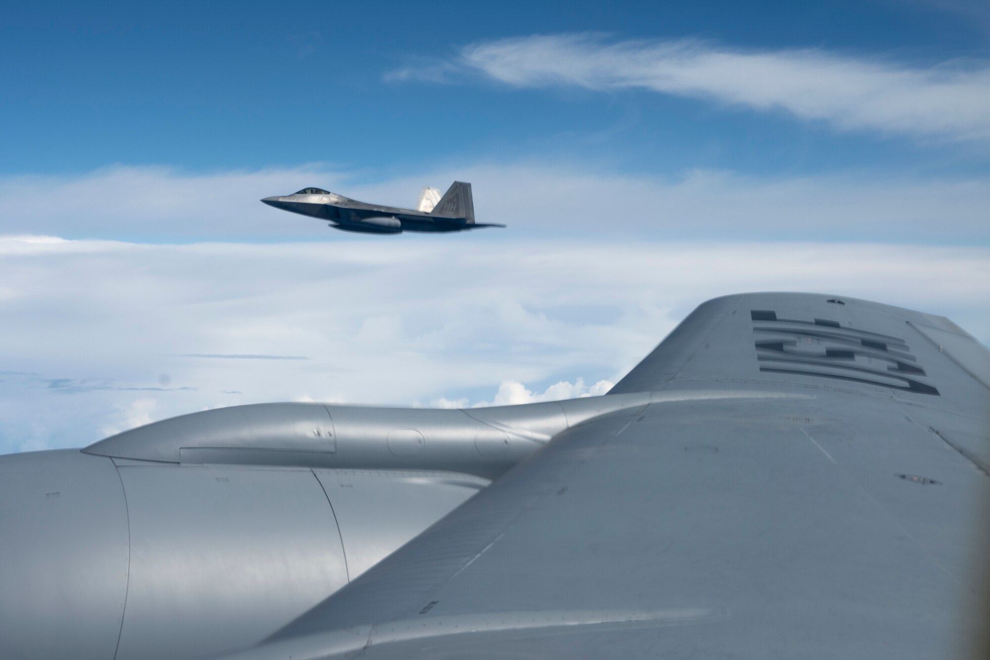 A Hawaii Air National Guard F-22 Raptor flies with a KC-135 Stratotanker from the 203rd Air Refueling Squadron March 10, 2021, near Oahu, Hawaii. Raptors trained with F-16 Fighting Falcons from Eielson Air Force Base, Alaska, during a final training sortie for exercise Pacific Raptor.
