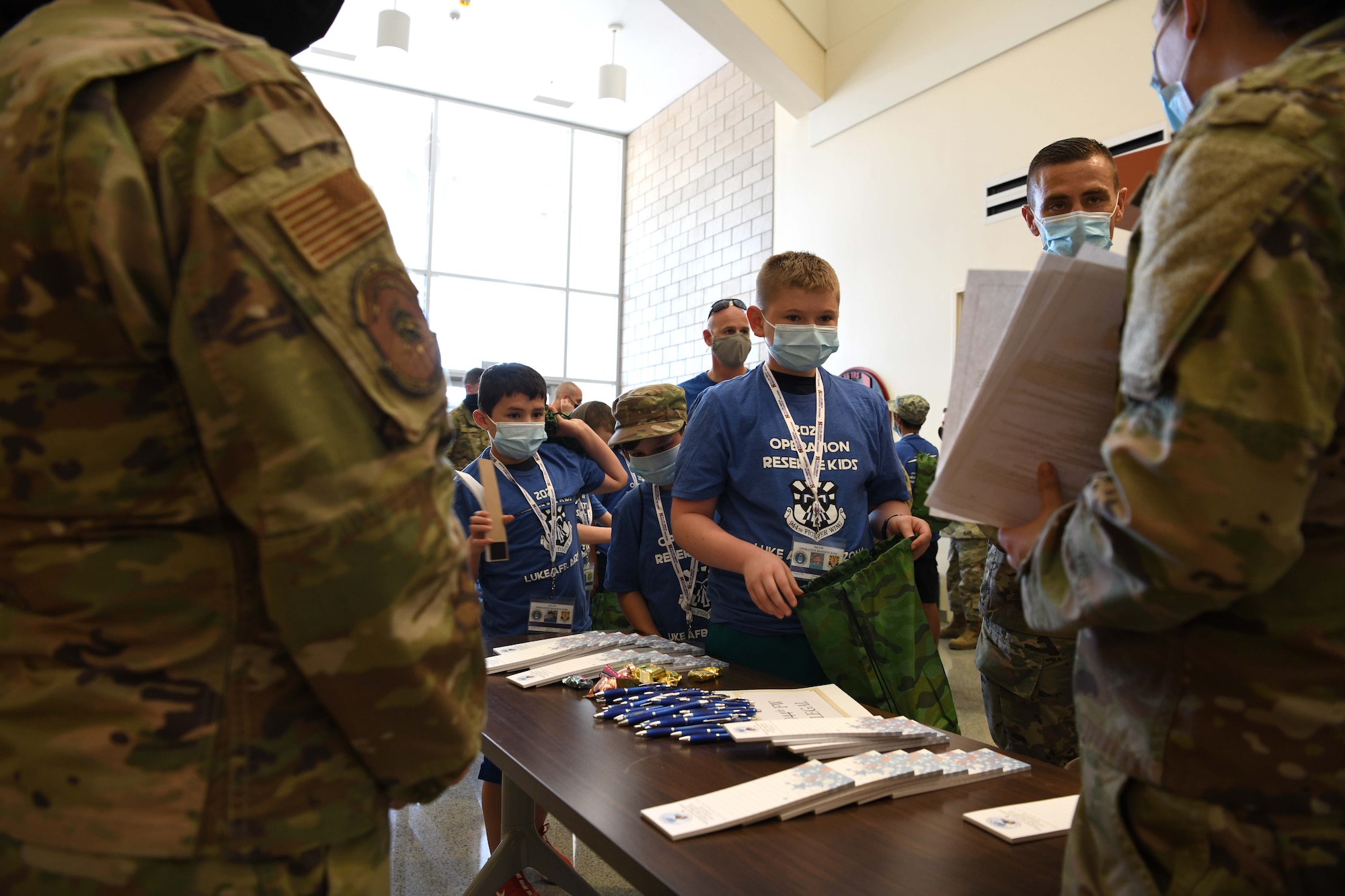 Reserve Citizen Airmen children walk through a mock pre-deployment line during Operation Reserve Kids at Luke Air Force Base, Arizona, April 10, 2021. During the event, the children processed through the pre-deployment line to gain a better understanding of the administrative side of what their parents are responsible for before departing.