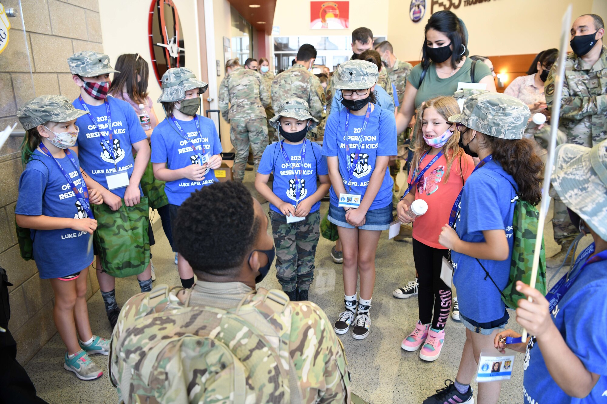 Reserve Citizen Airmen children listen to their team lead, 2nd Lt. Solomon Waddles, 944th Maintenance Group, as he introduces himself during Operation Reserve Kids at Luke Air Force Base, Arizona, April 10, 2021. The children got a behind-the-scenes look at an F-16 Fighting Falcon and F-35 Lightning, met some retired working dogs, ate field rations, and shot at targets with paintball guns.