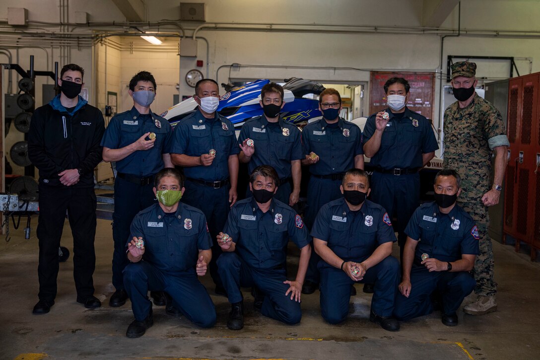 U.S. Marine Corps Brig. Gen. William Bowers, commanding general of Marine Corps Installations Pacific, poses with emergency service members for a group photo on Camp Schwab, Okinawa, Japan, April 2, 2021. First responders with the Camp Schwab Fire Department were recognized and presented with challenge coins by MCIPAC for saving the lives of seven Marines stranded while swimming recreationally near Ginoza, Japan. (U.S. Marine Corps photo by Lance Cpl. Zachary Larsen)
