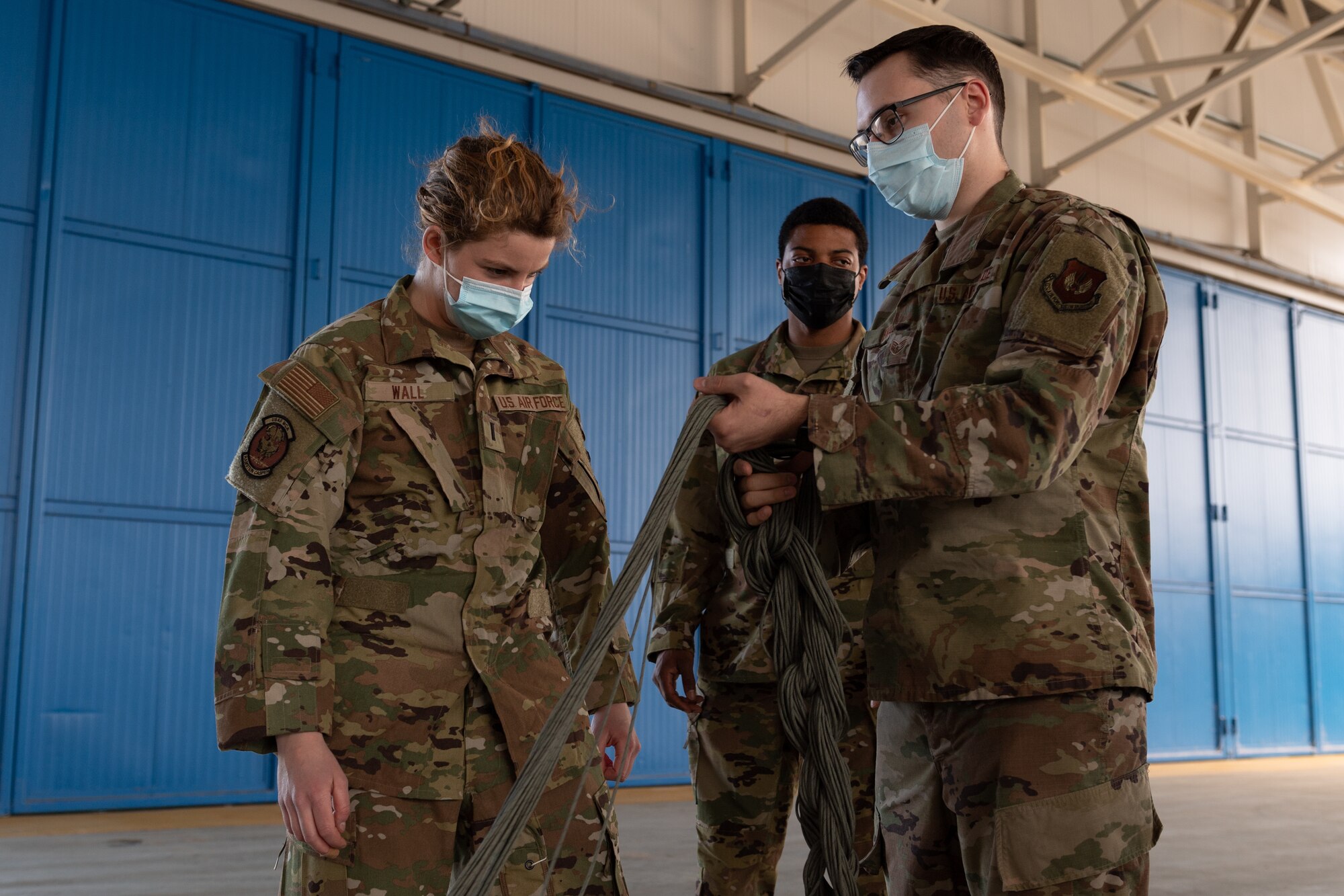 Airmen holding a parachute line.