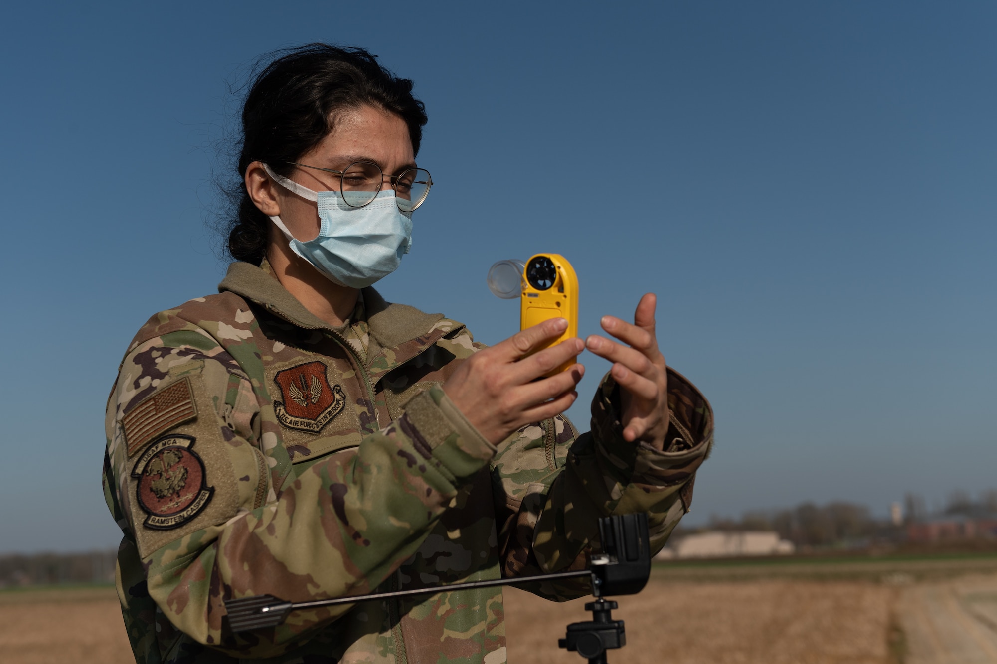 Airman holding wind measuring instrument.
