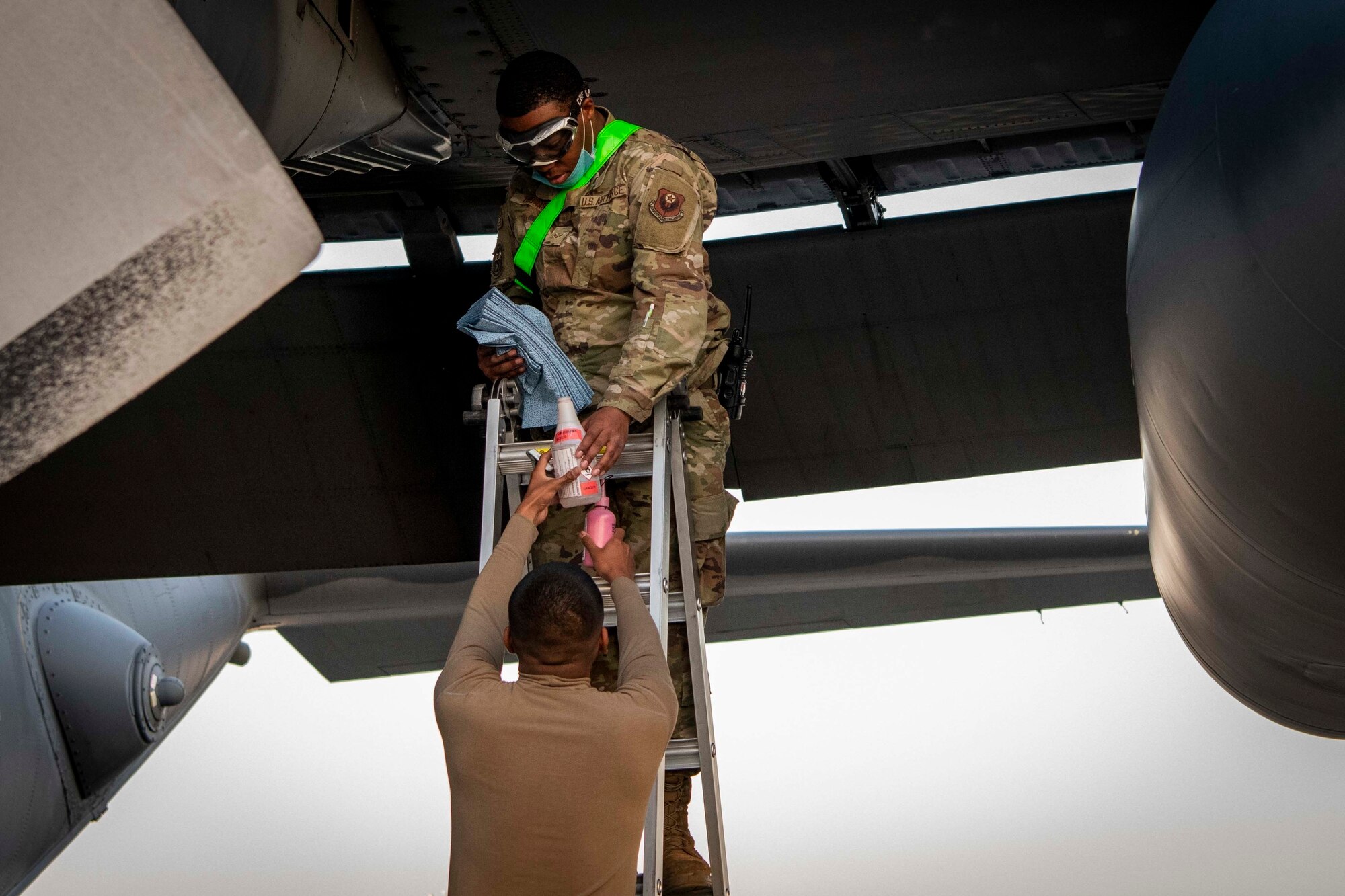U.S. Air Force Senior Airman Henry Rivas, a fuels systems apprentice assigned to the 1st Special Operations Maintenance Squadron, hands equipment to U.S. Air Force Airman 1st Class Justin Thomas, a fuels systems apprentice assigned to the 1st SOMXS, before checking for a fuel leak on an MC-130H Combat Talon II at Hurlburt Field, Florida, April 5, 2021.