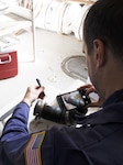 Chief Warrant Officer William Hockensmith, a marine inspector at Coast Guard Marine Safety Unit Portland, documents a damaged pipe during an inspection of the small passenger vessel Adventure Bound at a dry dock in Ilwaco, Washington, March 9, 2020. Small passenger vessels like the Adventure Bound that operate in saltwater routes are required to receive dry dock inspections every two years. (U.S. Coast Guard photo by Petty Officer 1st Class Levi Read)