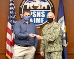 Capt. Jip Mosman, commander, Puget Sound Naval Shipyard & Intermediate Maintenance Facility, presents Bryson Delima, 2380.1RW Radioactive Waste branch head, with a Bravo Zulu sticker April 7, 2021,for co-leading a team with Mike Tracy, process management branch manager, Code 220, Resources, Training & Processes, that codified a sustainable engineering execution system, which was shared with all four U.S. Navy shipyards. Their combined efforts improved the turnaround time for Deficiency Log resolution from 2.4 days to less than one day by addressing visibility and behaviors at all levels of the command.