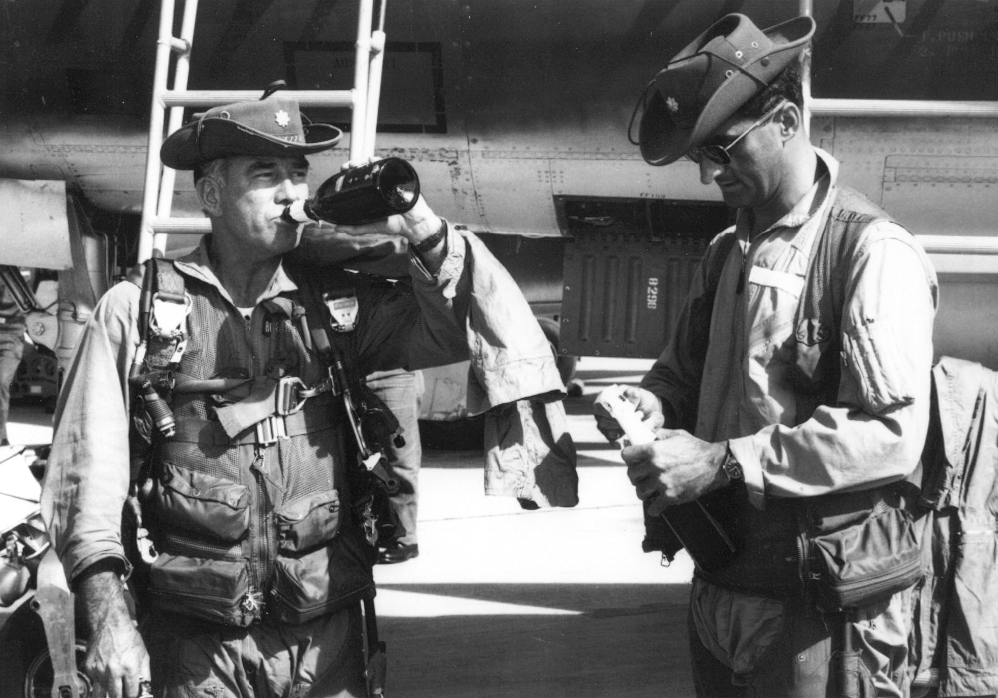 Maj. William Robinson, pilot (l), and Maj. Peter Tsouprake, EWO (r), celebrate their 100th mission. Earlier, on July 5, 1966, they flew lead on a large strike mission north of Hanoi. Disregarding their own safety, they braved intense ground fire and several SAMs to attack four SA-2 sites. Three were knocked out and the fourth was heavily damaged. For their valor, they were both awarded the Air Force Cross. (U.S. Air Force photo)