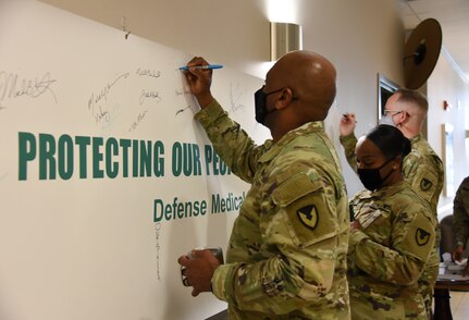 Col. Clayton Carr and others leaders at U.S. Army Medical Logistics Command sign a banner during a kickoff event April 2 to mark AMLC’s month-long observance of Sexual Assault Awareness and Prevention Month at Fort Detrick, Maryland.