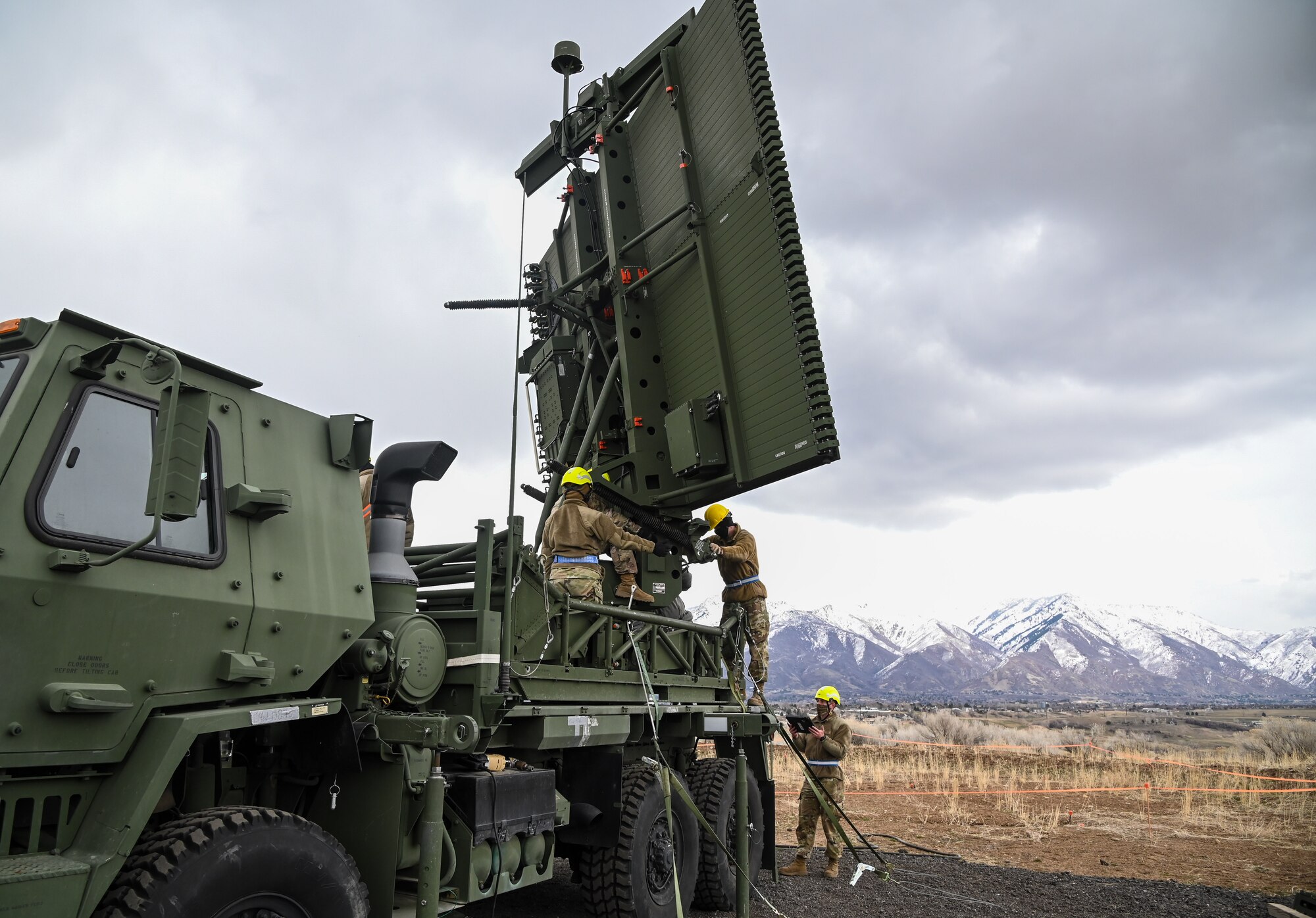 Three Airmen working on an AN/TPS-75 radar system.