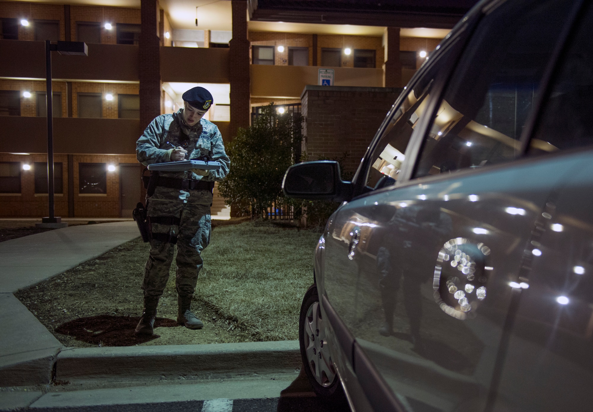 Airman 1st Class Kaitlyn Evans prepares a vehicle parking ticket during her night-shift duty at Joint Base Andrews, Maryland. Evans maintains proficiency while balancing her career and ownership of a horse with support from friends and family. She is an 11th Security Forces Squadron patrolman at Andrews Air Force Base, Maryland. (U.S. Air Force photo/Staff Sgt. Vernon Young Jr.)