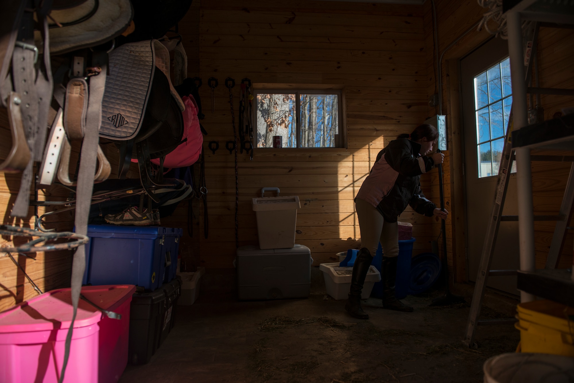 Airman 1st Class Kaitlyn Evans sweeps a shed inside of a barn that houses her horse, Kobalt, in Lothian, Maryland. Evans spends about two hours a day cleaning and caring for Kobalt in addition to her day-to-day tasks. When she cannot make it to care for Kobalt, she relies on friends and the barn owner to provide care. Evans is an 11th Security Forces Squadron patrolman at Andrews Air Force Base, Maryland. (U.S. Air Force photo/Staff Sgt. Vernon Young Jr.)