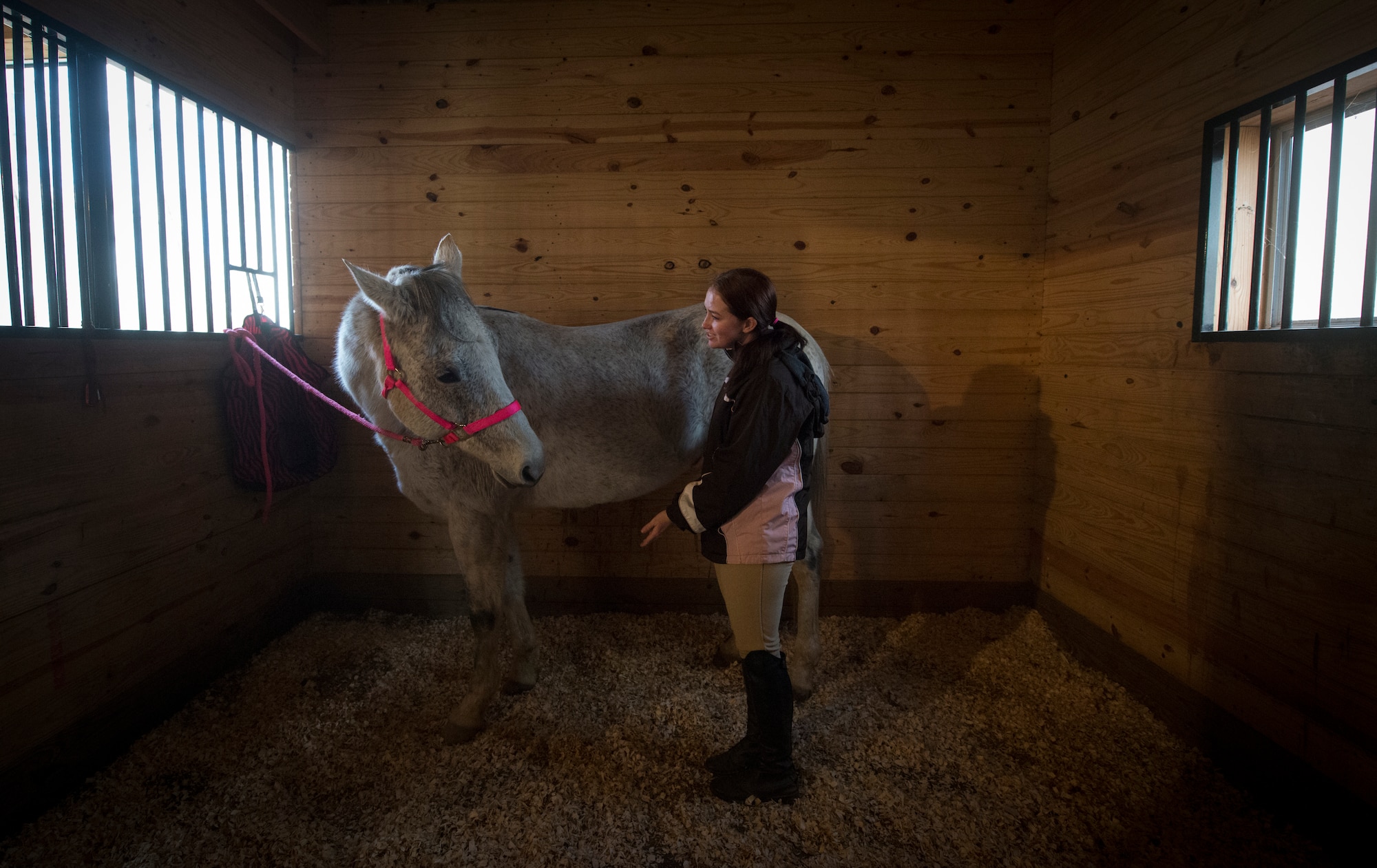 Airman 1st Class Kaitlyn Evans guides Kobalt after cleaning him inside a horse stable in Lothian, Maryland. Evans, a North Carolina native and 11th Security Forces Squadron patrolman at Andrews Air Force Base, Maryland, relocated her horse at her own expense to continue participating in competitions with the horse. She often compares spending time with her horse to being with a family member in her hometown. (U.S. Air Force photo/Staff Sgt. Vernon Young Jr.)