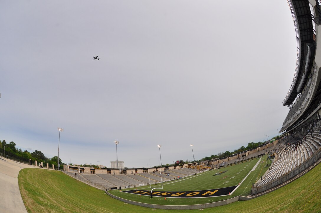 C-130 flying over a stadium