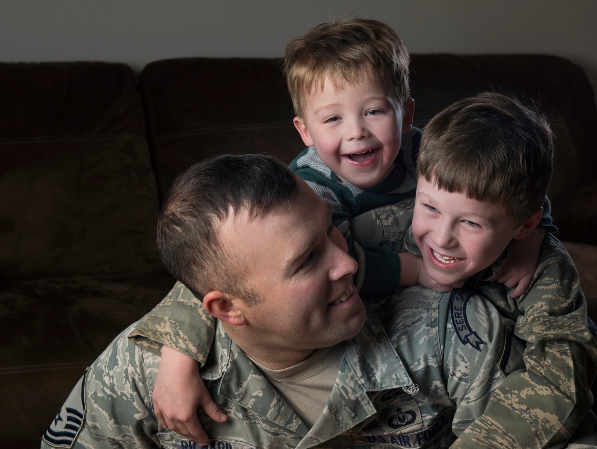Master Sgt. Marc Richard, Det. 1, 66th Training Squadron, Arctic Survival School superintendent, smiles for a portrait with his sons Conner and Colton at their home in North Pole, Alaska. Although the Richard family is approaching their fifth deployment, they've kept their daily routine the same and will do what Richard and his wife, Paulle, have been doing for years -- press on. (U.S. Air Force photo/Staff Sgt. Vernon Young Jr.)