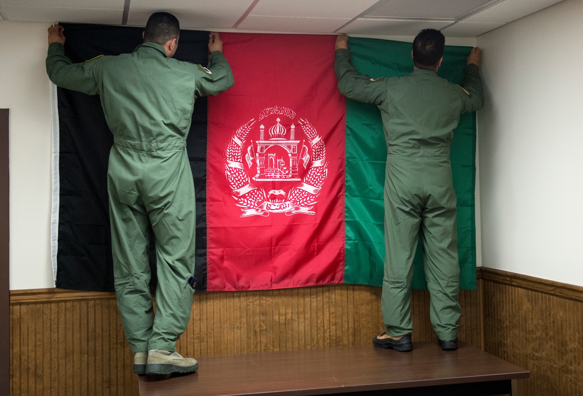 Afghan student pilots hang an Afghan flag on the wall of their training room at the 81st Fighter Squadron, Moody Air Force Base, Georgia. Moody was selected to host the training because of the available airspace, airfield and suitable facilities. (U.S. Air Force photo/Master Sgt. Jeffrey Allen)