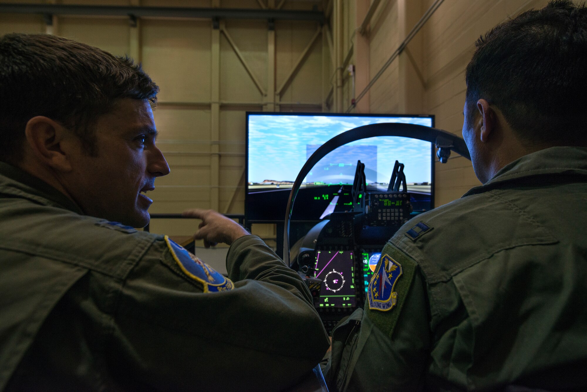 A U.S. Air Force instructor pilot assigned to the 81st Fighter Squadron, Moody Air Force Base, Georgia, reviews the flight after an Afghan student pilot landed in the A-29 Super Tucano flight simulator. Students work with their U.S. instructors to build familiarity and proficiency in the simulator before flying the A-29. The A-29 is a two-seat aircraft, allowing students to fly with U.S. instructor pilots in the back seat. The American instructor pilot can take control of the aircraft at any time, but the students are expected to fly the aircraft through the entire mission. (U.S. Air Force photo/Master Sgt. Jeffrey Allen)