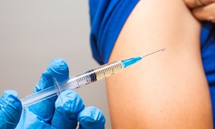 A needle is held hear a patients arm before a shot is administered