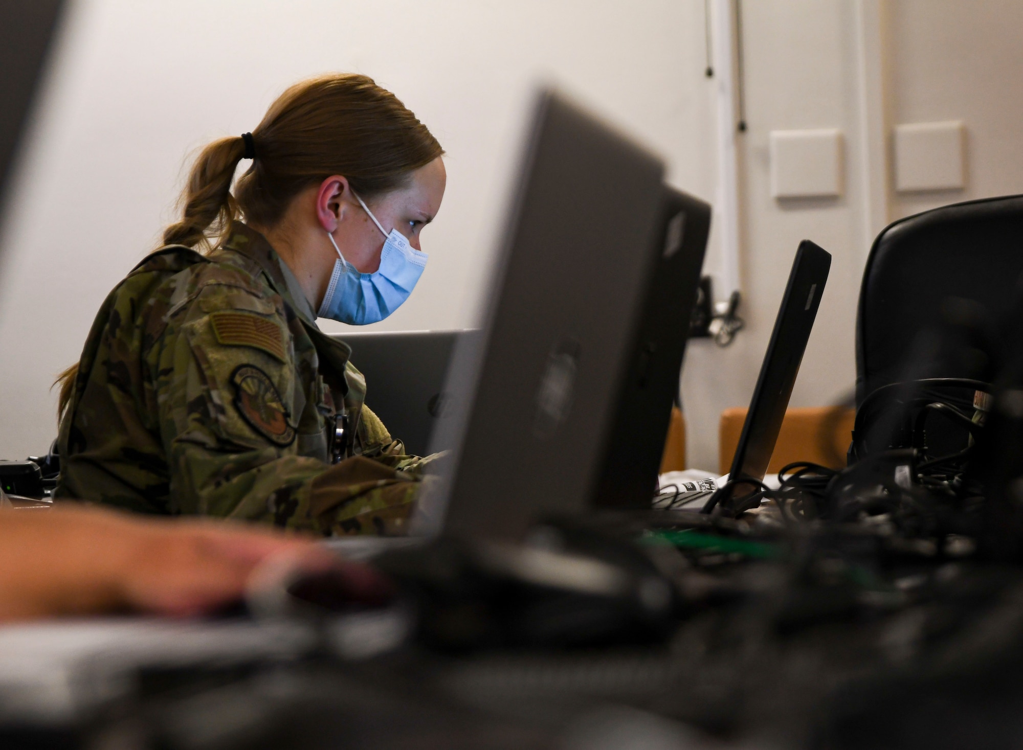 A photo of an airman sitting in front of a computer