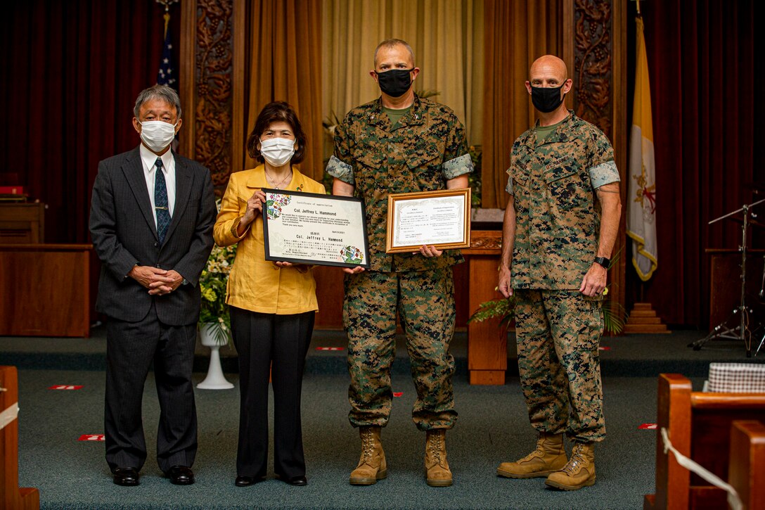 U.S. Marine Corps Col. Jeffrey L. Hammond, commanding officer of Headquarters and Support (H&S) Battalion, Marine Corps Installations Pacific (MCIPAC), and Sgt. Maj. Brian Drechsler, the sergeant major of H&S Battalion, MCIPAC, and volunteers with the Okinawa Prefecture Welfare Center and Women’s of Wings organizations pose for a photo at the Camp Foster Chapel, Okinawa, Japan, April 9, 2021. The Okinawa Prefecture Welfare Center and Women’s of Wings organizations received a charitable donation from the Camp Foster Chapel congregation in support of their mission. The organization volunteers then presented service members and civilians with a Certificate of Appreciation thanking them for their efforts. (U.S. Marine Corps photo by Cpl. Karis Mattingly)