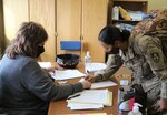 A Soldier from the California State National Guard’s 330th Military Police Company signs for her lodging key from Department of Public Works employee Ms. Martha Kimball at the Fort Greely Barracks March 30. The group of Soldiers have mobilized to support security efforts led by the 100th Missile Defense Brigade and the 49th Missile Defense Battalion at Fort Greely.