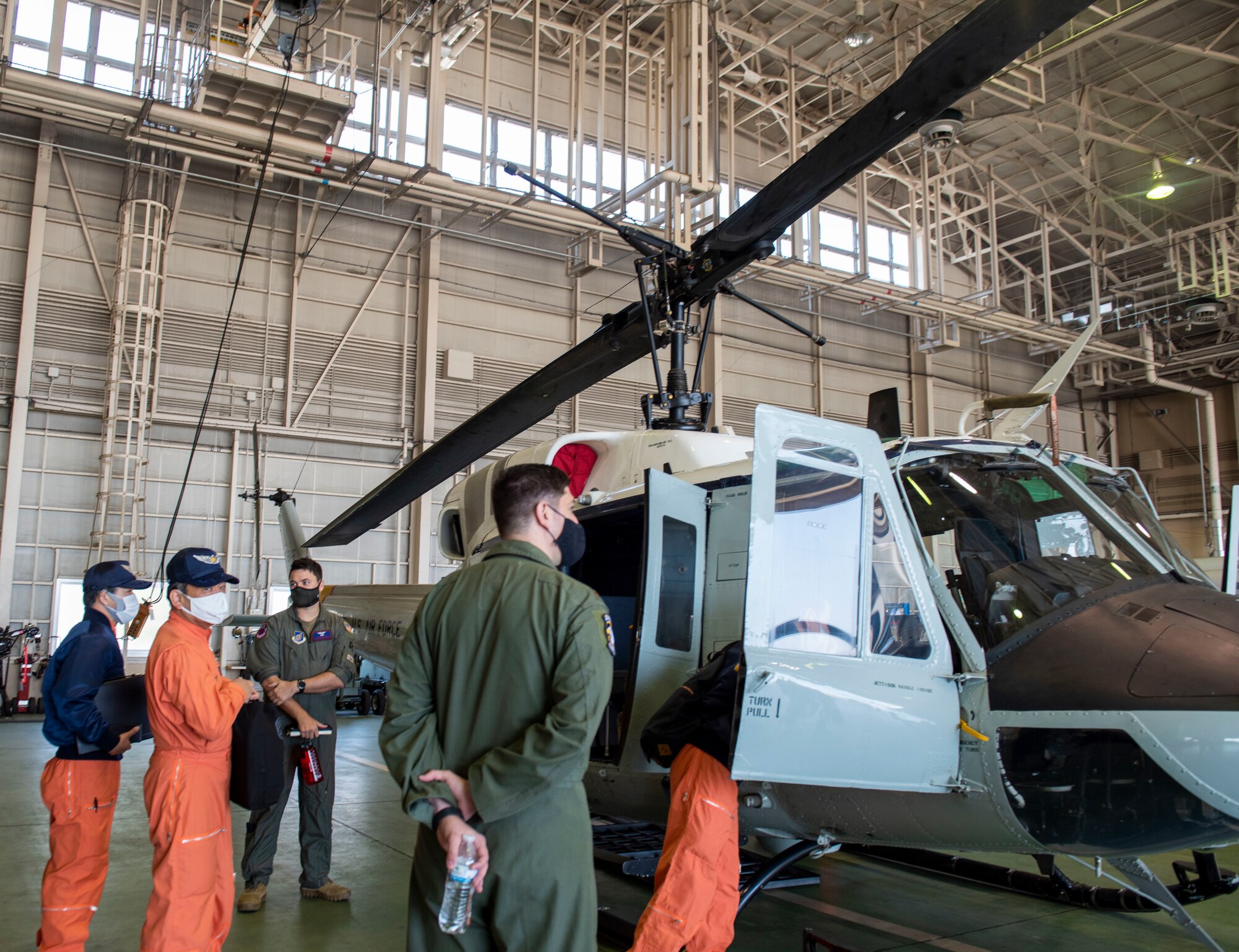 Tokyo Metropolitan Police and Japan Coast Guardsmen inspect a UH-1N