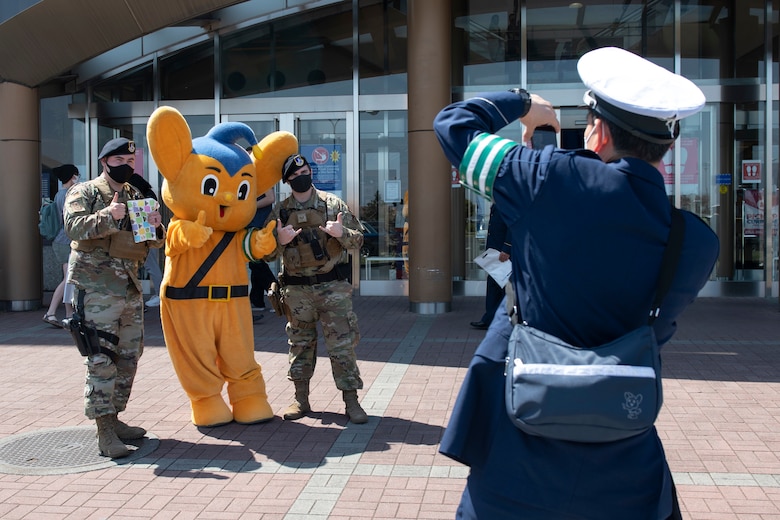 A Japanese National Police officer takes a photo of two 374th Security Forces Squadron members with Pipo-kun, JNP mascot, at the Yokota Community Center on Yokota Air Base, Japan, April 11, 2021. Pipo-kun posed for photos during a traffic safety campaign tailored to Yokota members. (U.S. Air Force photo by Staff Sgt. Joshua Edwards