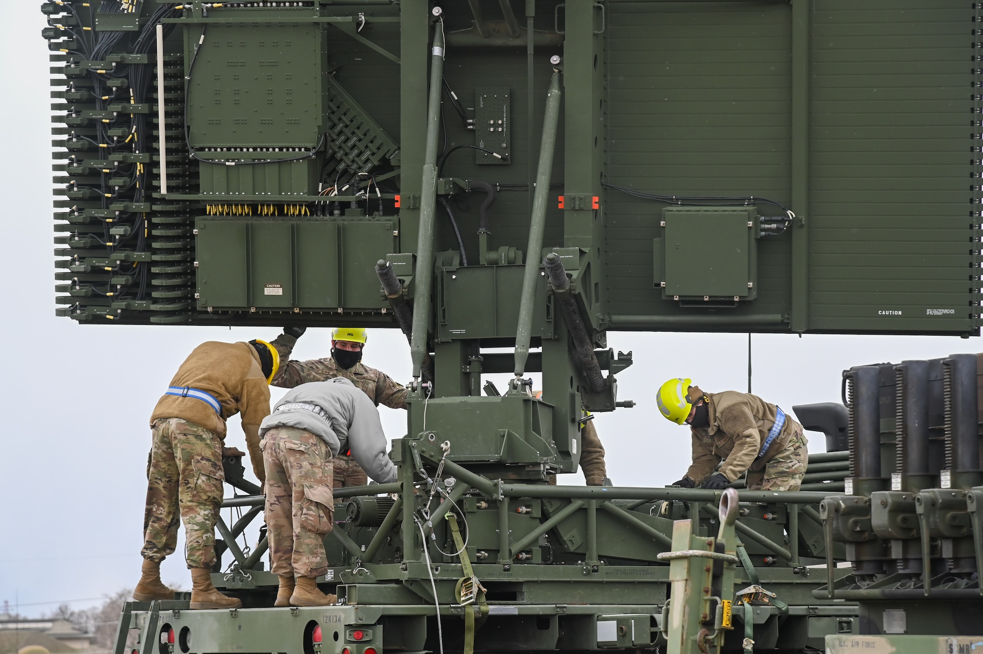Four Airmen working on a AN/TPS-75 radar system.