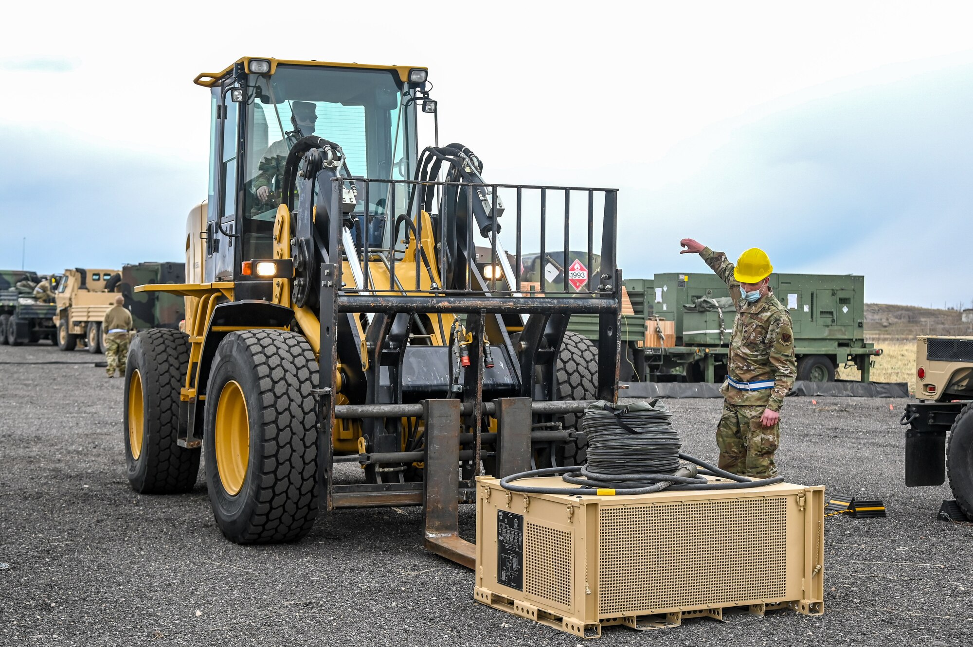 An Airman guides an electrical control unit onto a forklift.
