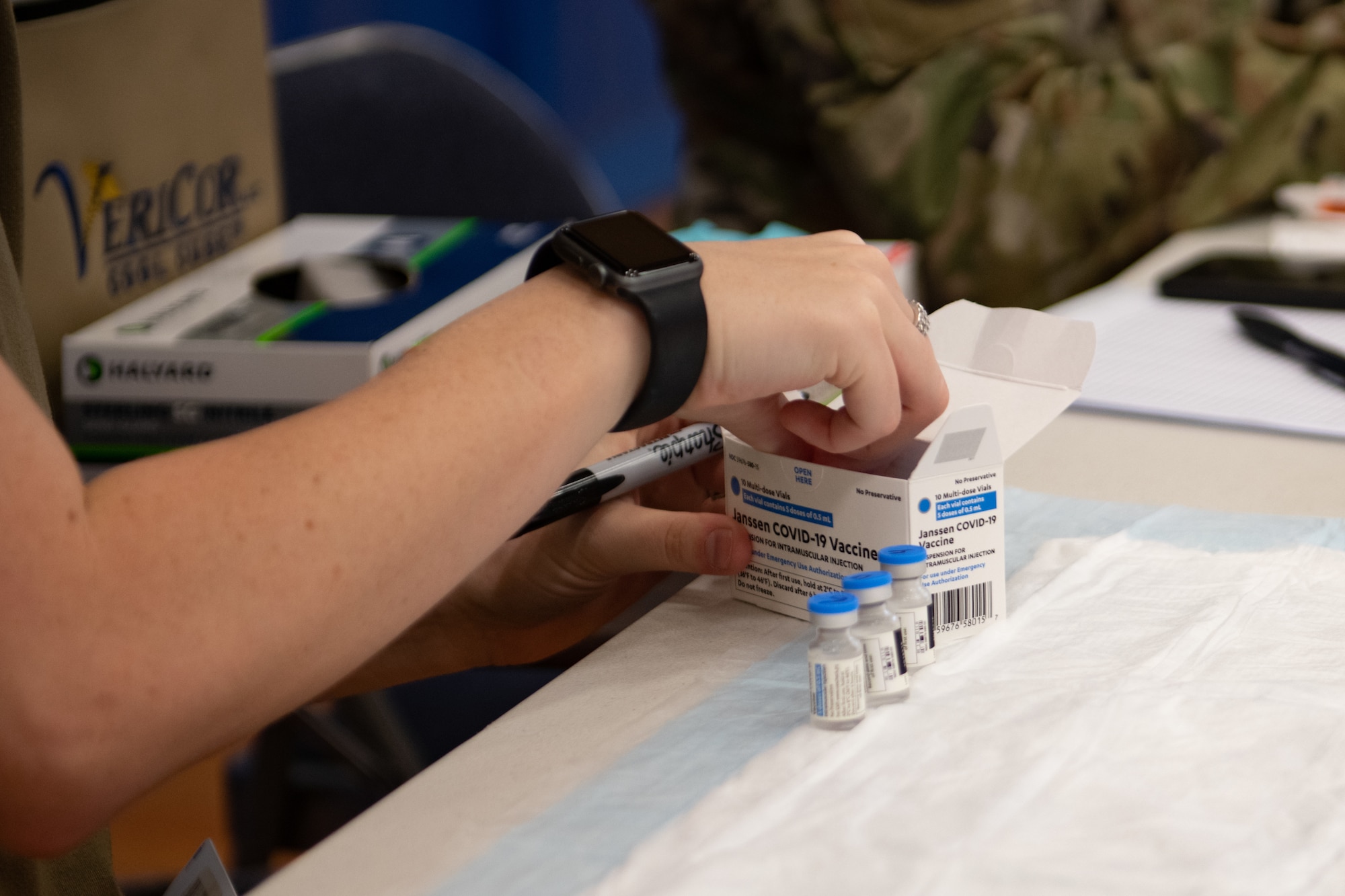 A U.S. Airman from the 18th Medical Group numbers vials of the Janssen COVID-19 vaccine.