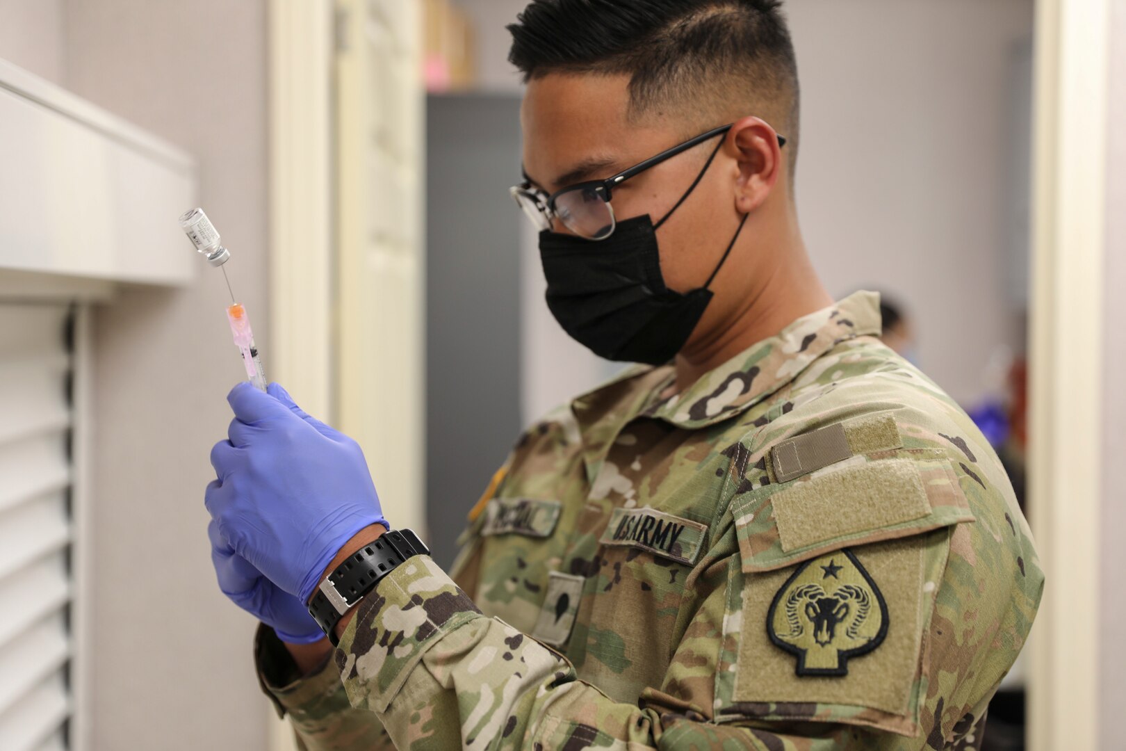 Nevada National Guard Spc. Exequiel Pascual with Joint Task Force 17 measures a dose of the Janssen vaccine at a mobile vaccination unit site in Pahrump, Nevada, April 8, 2021. The Guard and partners and helping facilitate access to the COVID-19 vaccine in rural Nevada.
