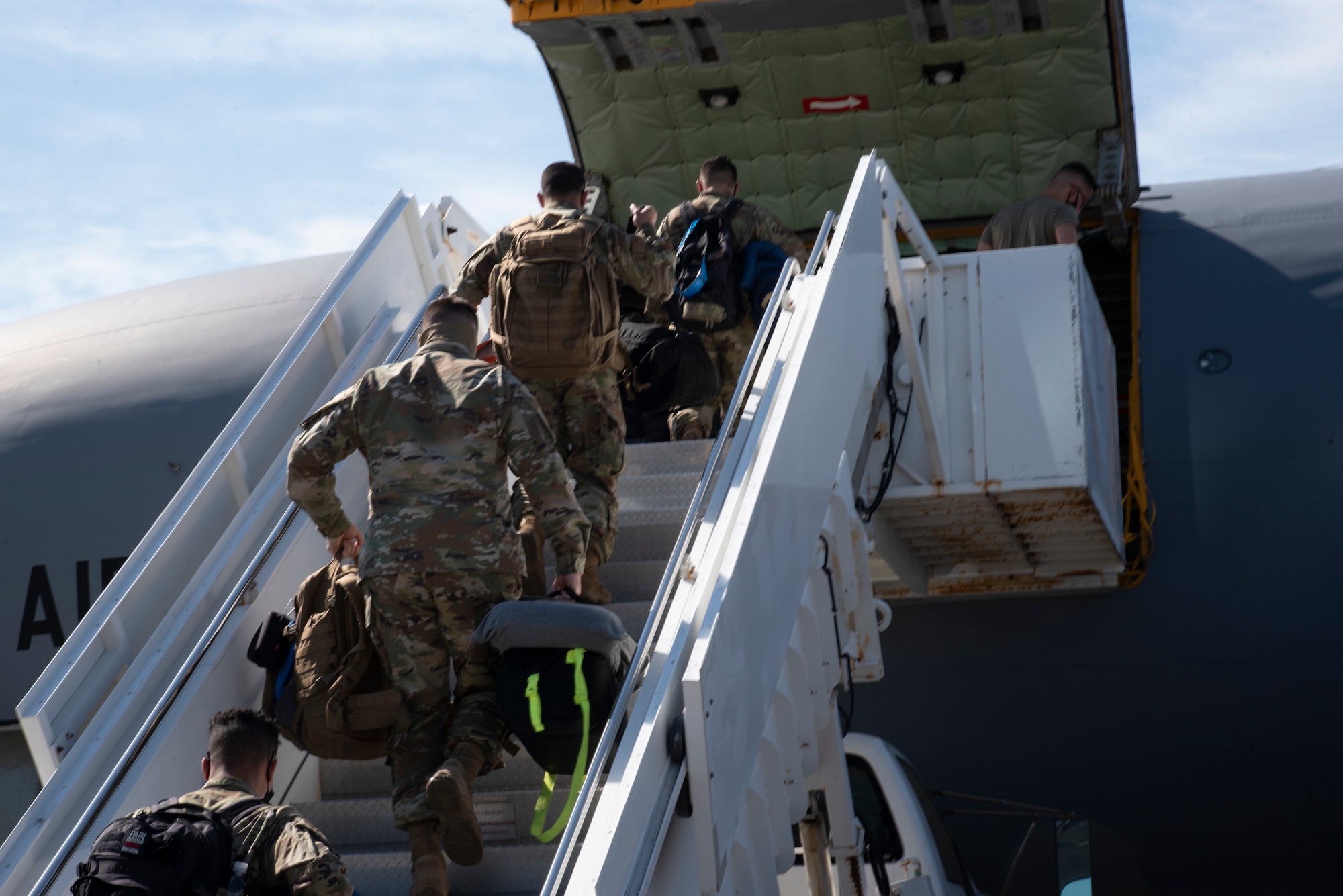 Team MacDill Airmen climb a set of air stairs to board a KC-135 Stratotanker aircraft on the flight line, April 8, 2021 at MacDill Air Force Base, Fla.