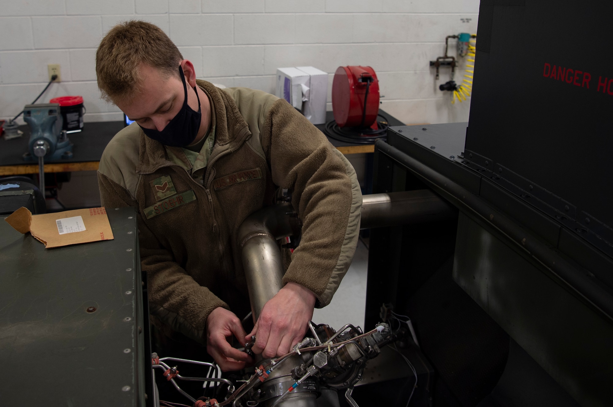 U.S. Air Force Senior Airman Zachary Stoehr, 62nd Maintenance Squadron Aerospace Ground Equipment Flight journeyman, performs maintenance to the butterfly valve of a piece of equipment that helps C-17 Globemaster IIIs start engines at Joint Base Lewis-McChord, Washington, April 7, 2021. The 62nd MXS AGE shop focuses on preventative maintenance for equipment going to the flightline to assist with inspecting or repairing aircraft. (U.S. Air Force photo by Senior Airman Tryphena Mayhugh)