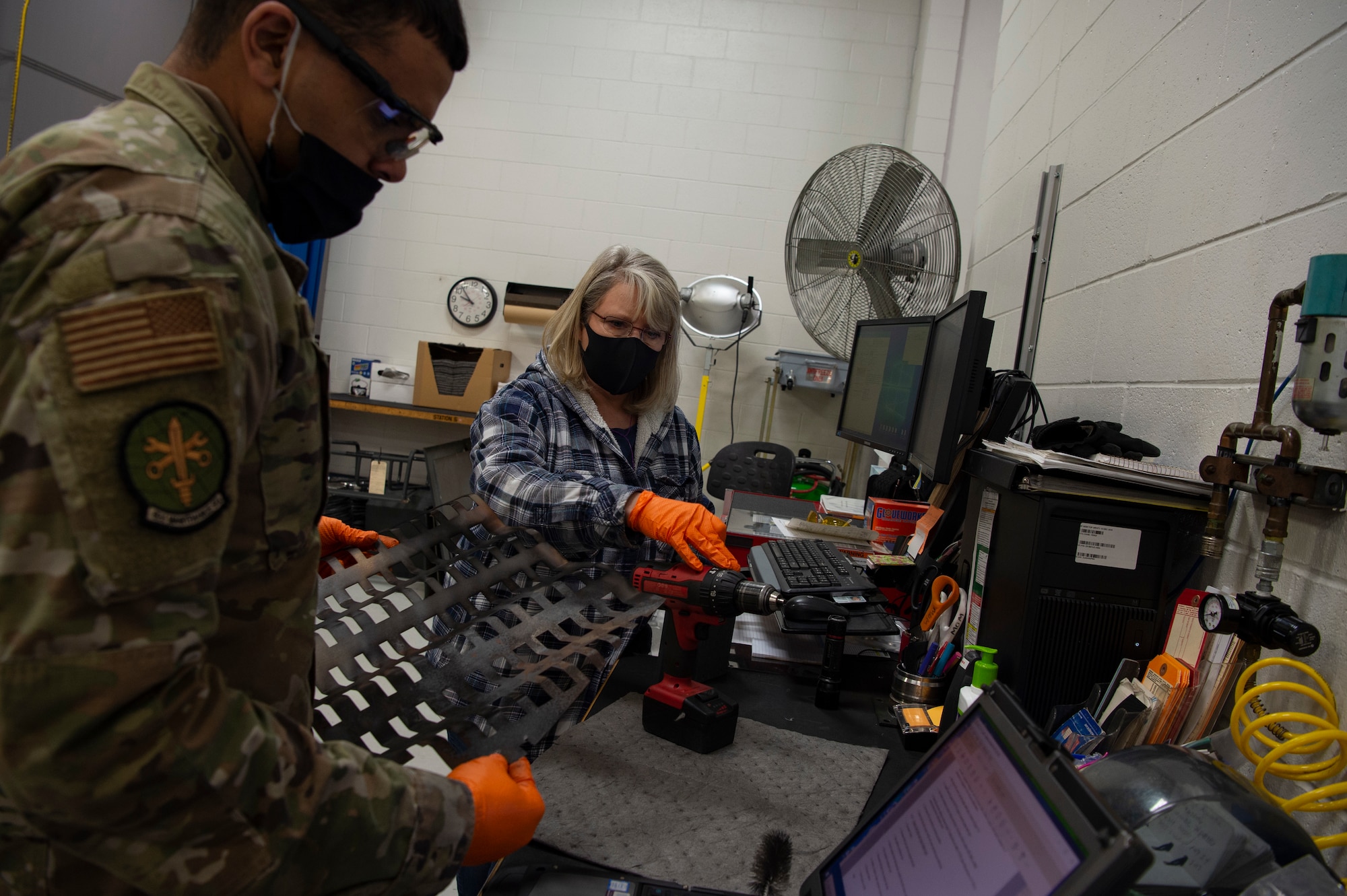 Lucinda Oglesby, right, 62nd Maintenance Squadron Aerospace Ground Equipment Flight mechanic, shows U.S. Air Force Airman Anthony Katoke, 62nd MXS AGE flight apprentice, how to properly clean parts of the combustion section for a generator heater at Joint Base Lewis-McChord, Washington, April 7, 2021. The 62nd MXS AGE flight consists of 44 total force personnel, to include active duty, reservists and civilians. (U.S. Air Force photo by Senior Airman Tryphena Mayhugh)